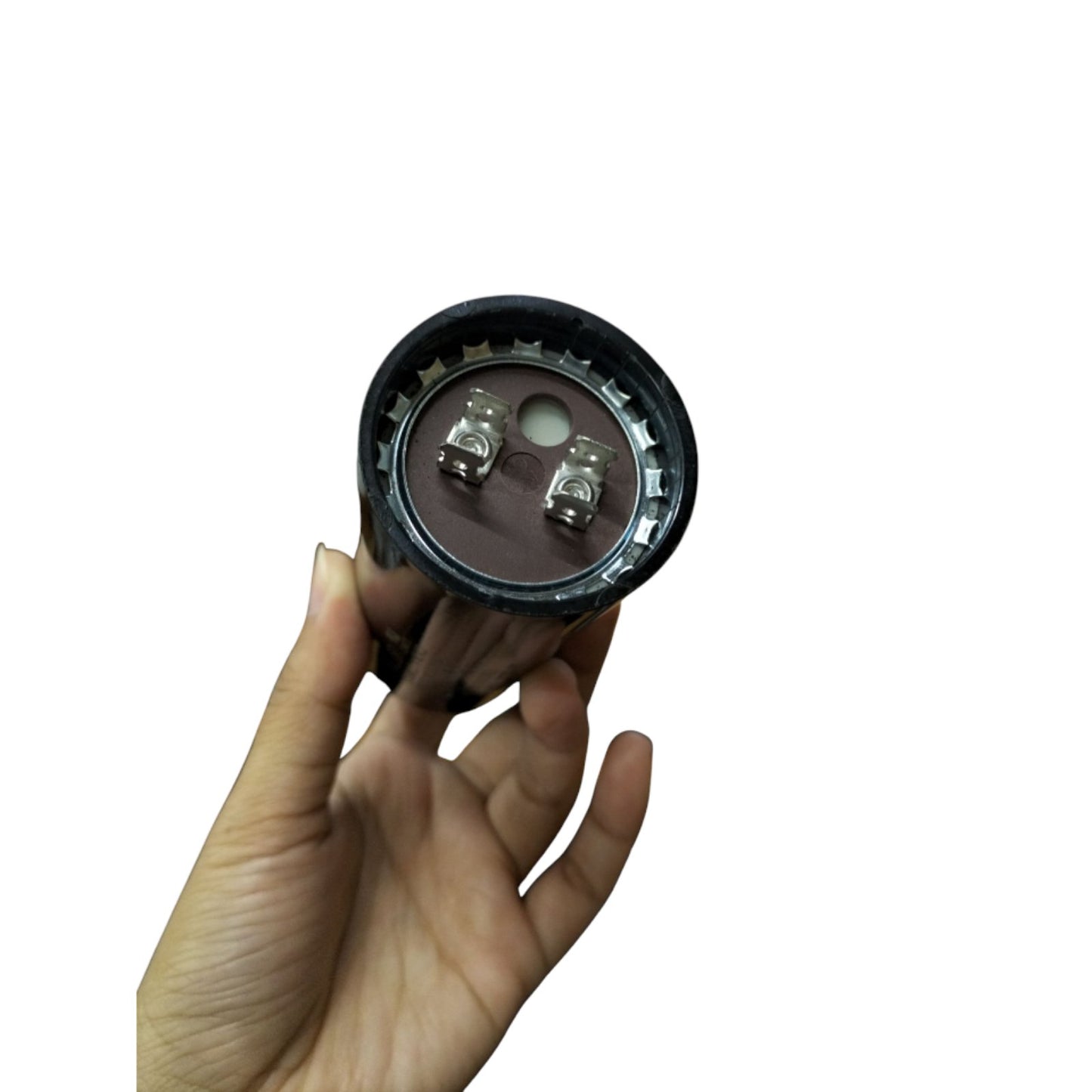 Hand holding a BMI Motor Starting Capacitor 270-324 UF with visible terminals for electrical applications
