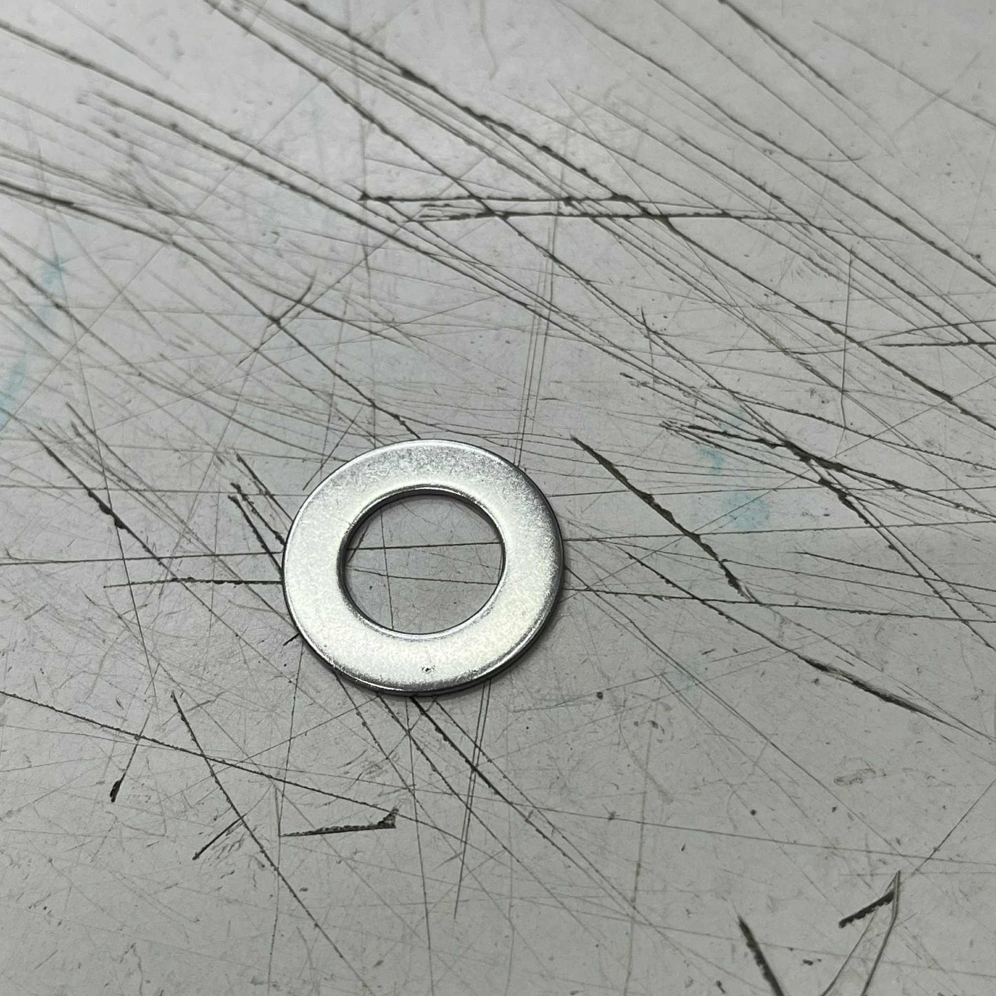 2cm Stainless Washer on a scratched metal surface for various fastening applications