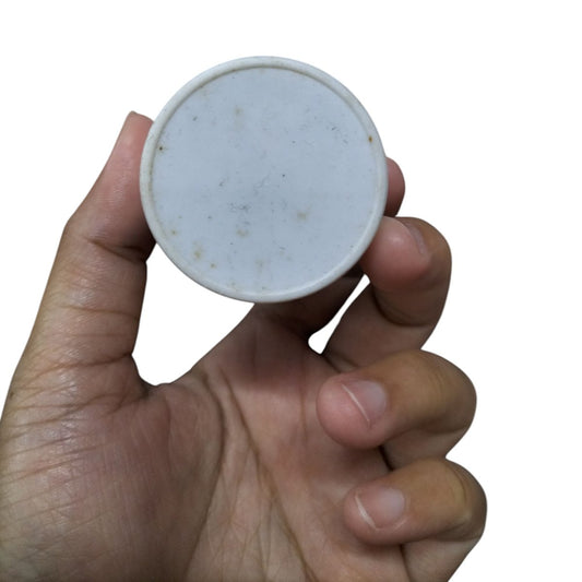 Syscap Running Capacitor 25MFD 350 VAC held by hand, showcasing the round design and smooth surface