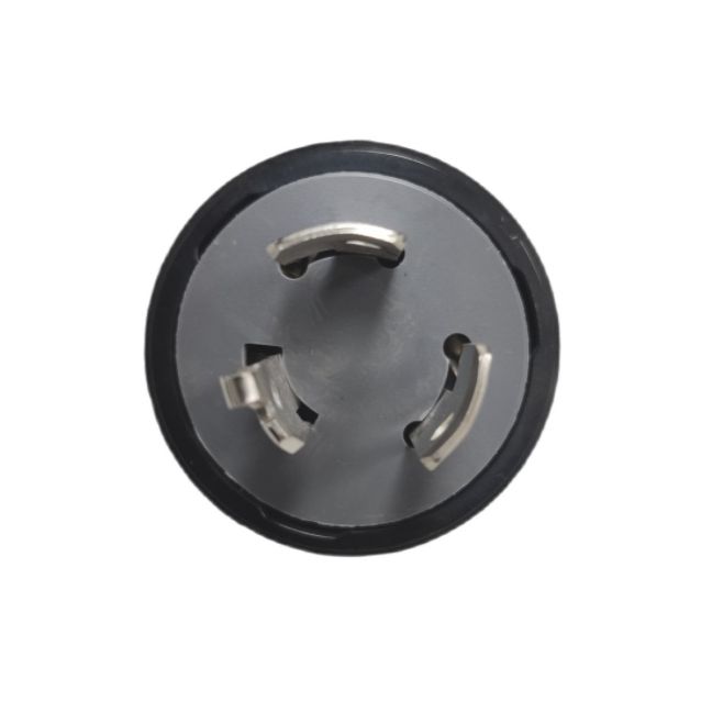 Close-up of a twist lock plug for industrial use showing metal prongs and durable housing