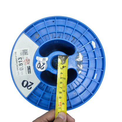 Top view of a blue 25kg plastic spool for wire with measurement tape for size reference