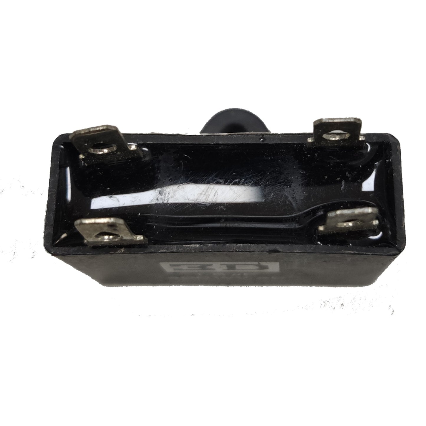 Black rectangular component with metal contacts on a white background