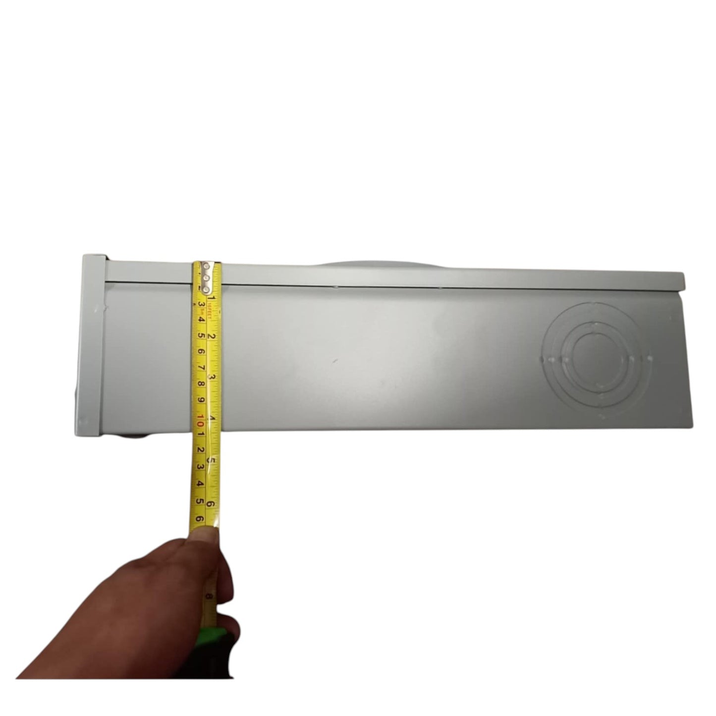 Hand holding a measuring tape against a rectangular object on a white background