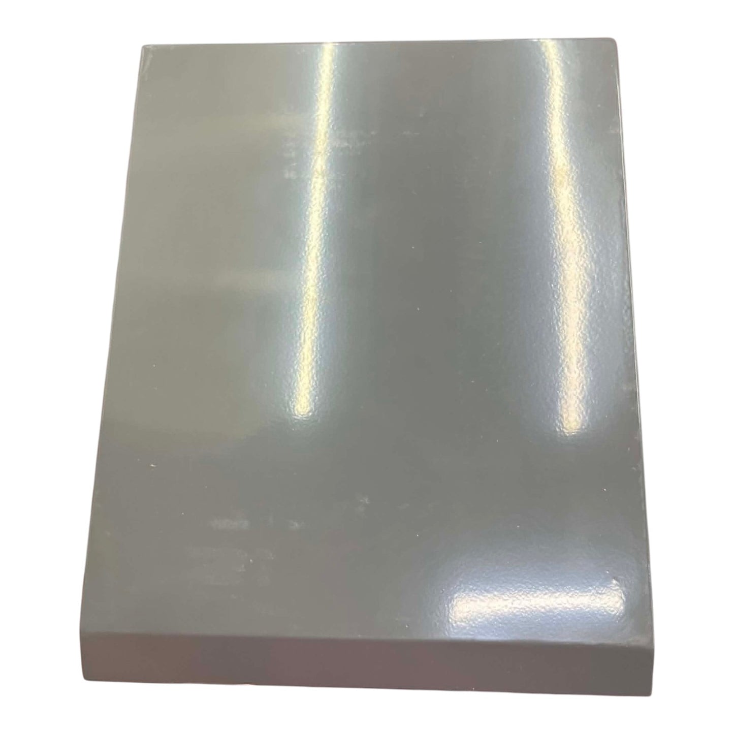 Rectangular piece of metallic material with reflective surface on a white background