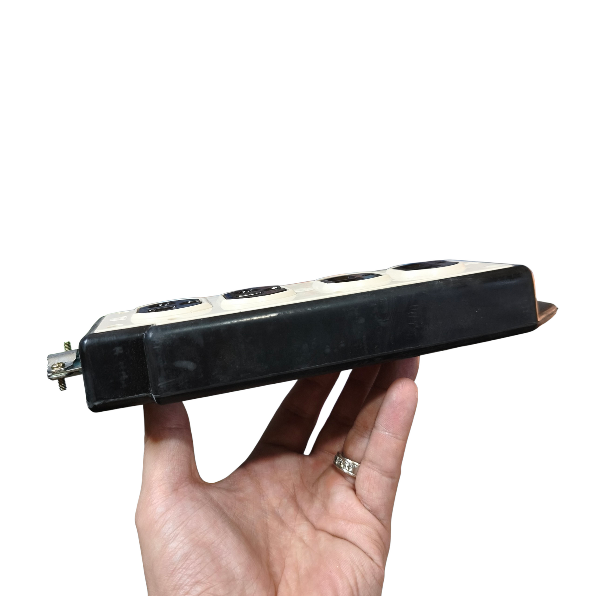 Hand holding a black electronic device with multiple sockets on a white background