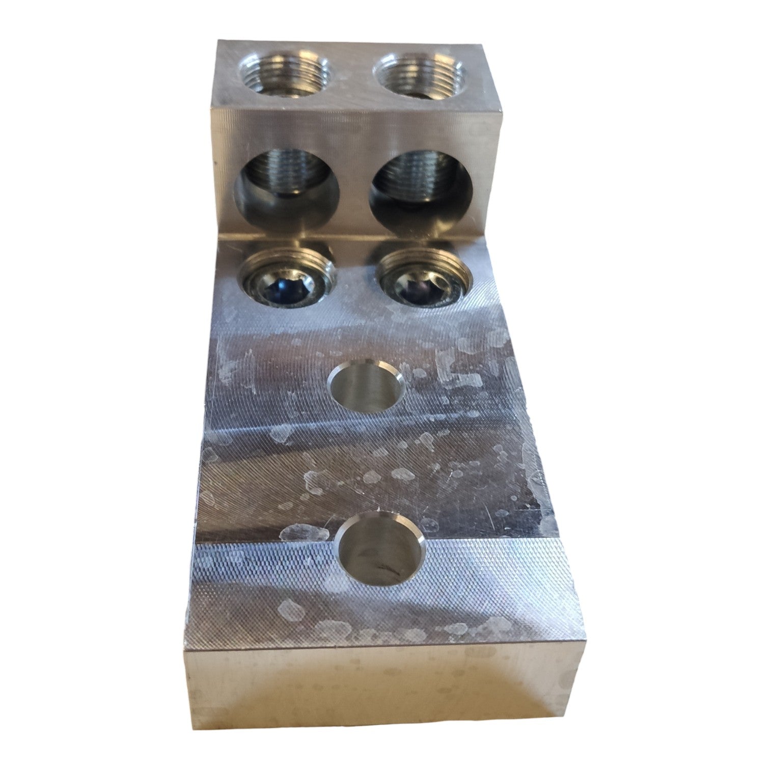 Metal block with threaded holes on a white background