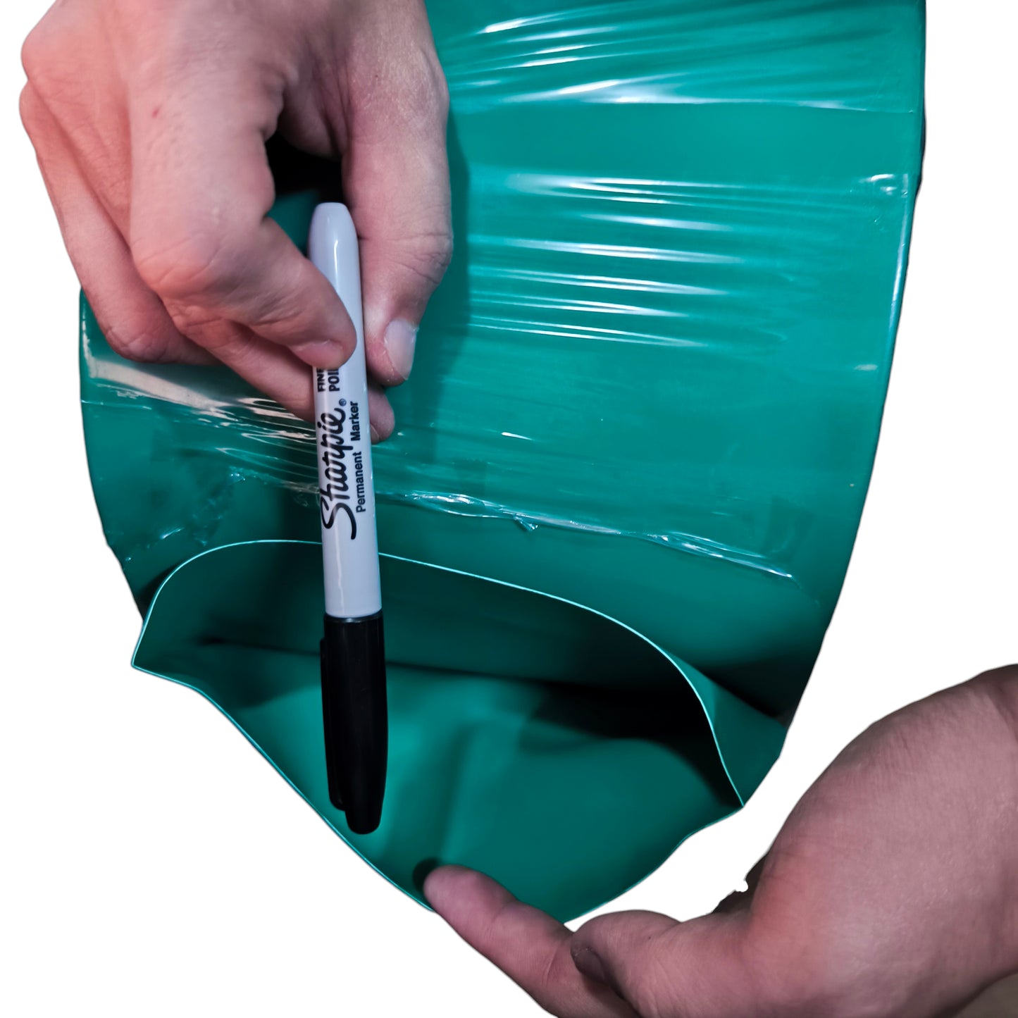 Hand holding a Sharpie marker over a green plastic sheet
