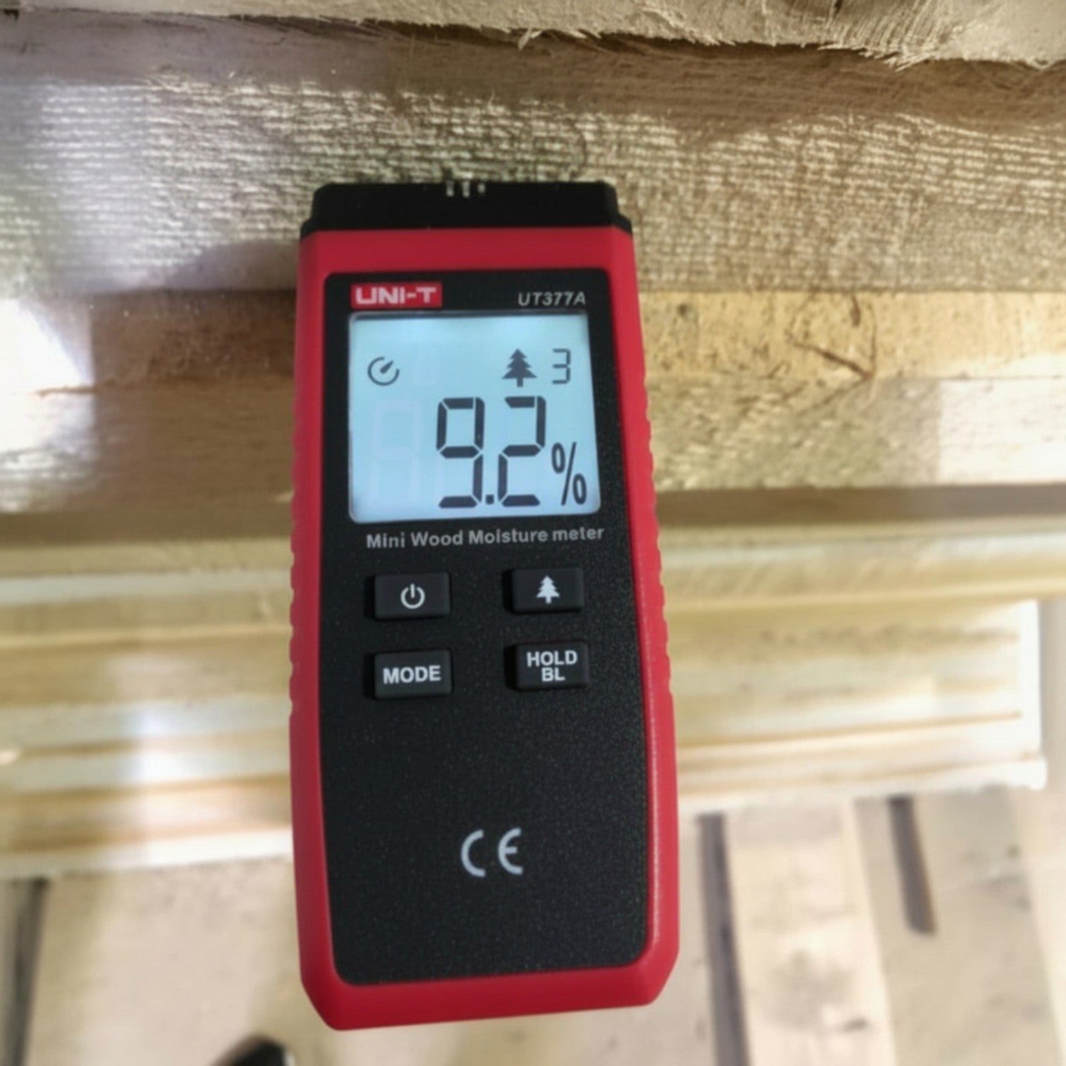 Red UNI-T moisture meter displaying 9.2% on a wooden background UNI-T Mini Digital Wood Moisture Tester UT377A with LCD Display Applicable for 4 Types of Wood Batteries not Included 3pcs AAA Electx Electrical SUpply