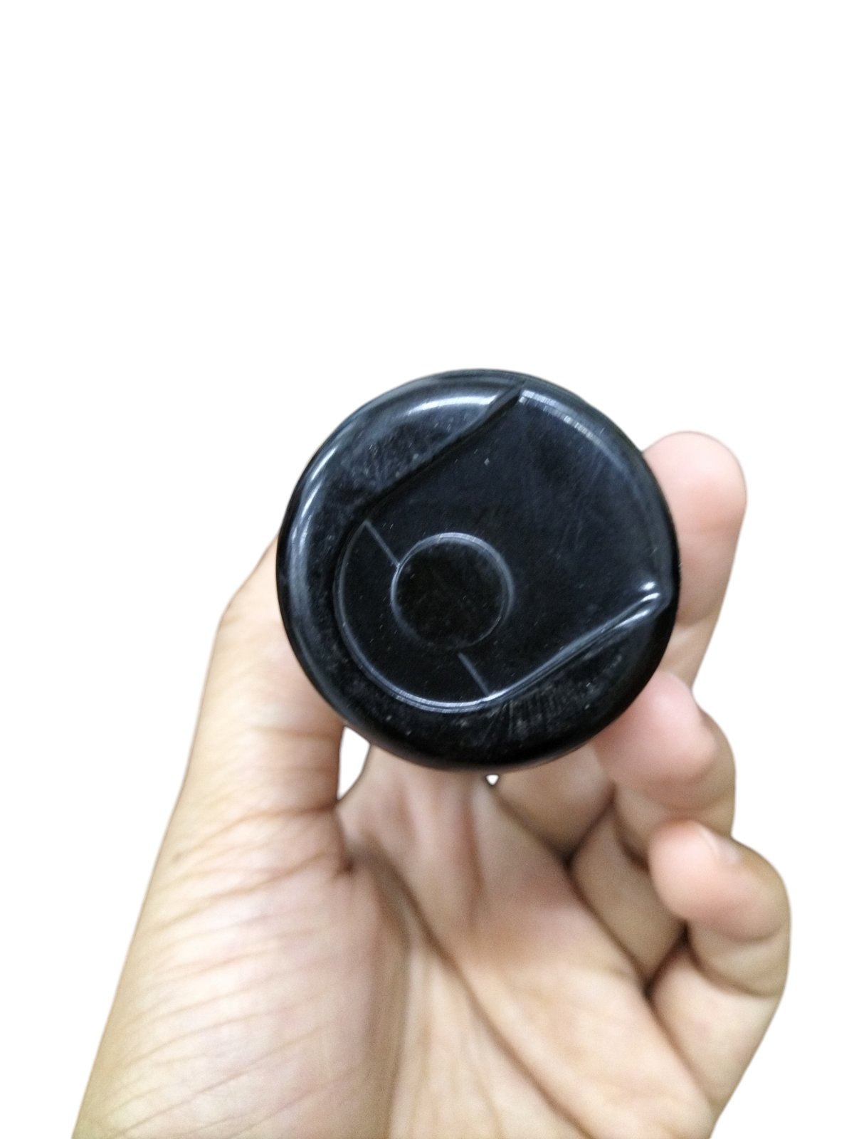 Hand holding a black Starting Capacitor 430-516UF ideal for electrical circuit applications