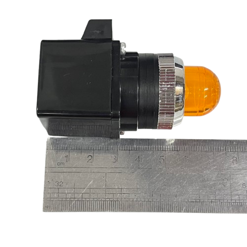 Auspicious 25mm yellow pilot lamp transformer type with chrome bezel and black plastic housing beside ruler for scale