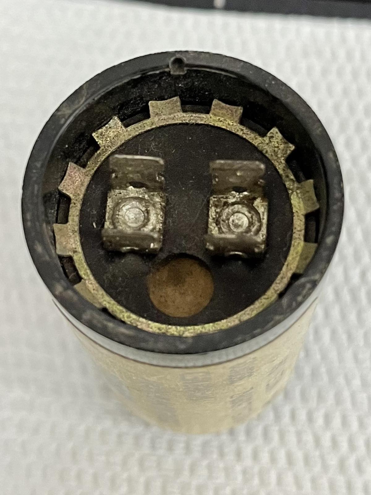 Close-up top view of BC Motor Starting Capacitor 141-169UF electrical circuitry part with terminals