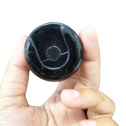 Starting Capacitor CDE Brand 324-388 MFD held between fingers, black electrical circuitry part