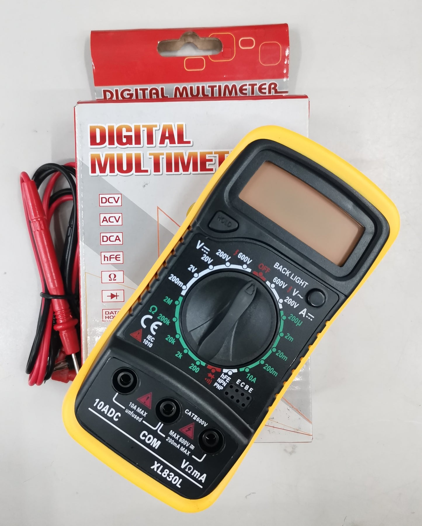 Yellow and black digital multi-meter with test probes and packaging for electrical measurements