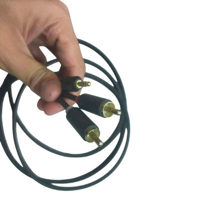 Hand holding a durable RCA to aux cable with gold connectors for high-quality audio connection