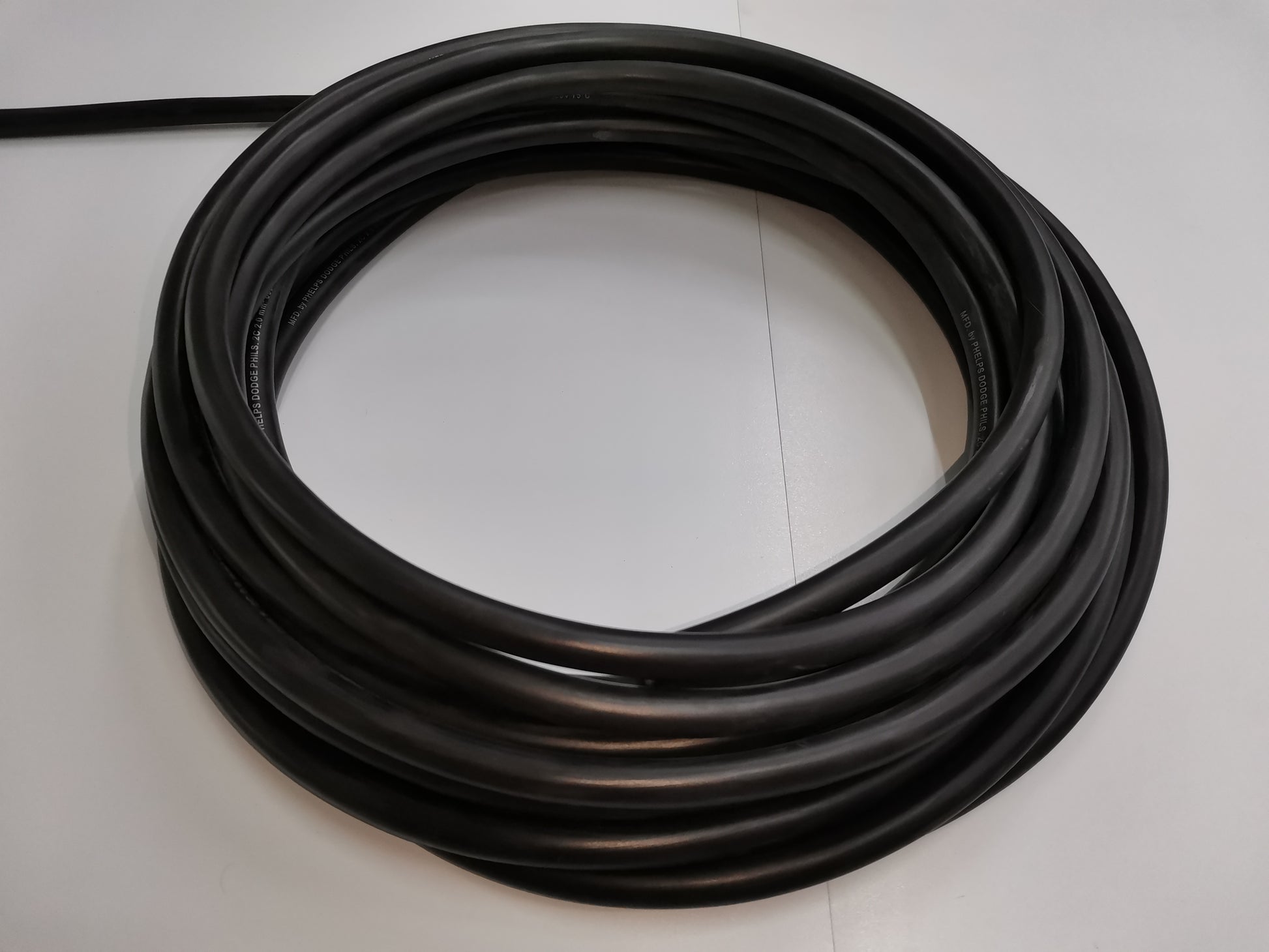 Phelps Dodge black 18 gauge 2 core electrical wire coiled on white surface