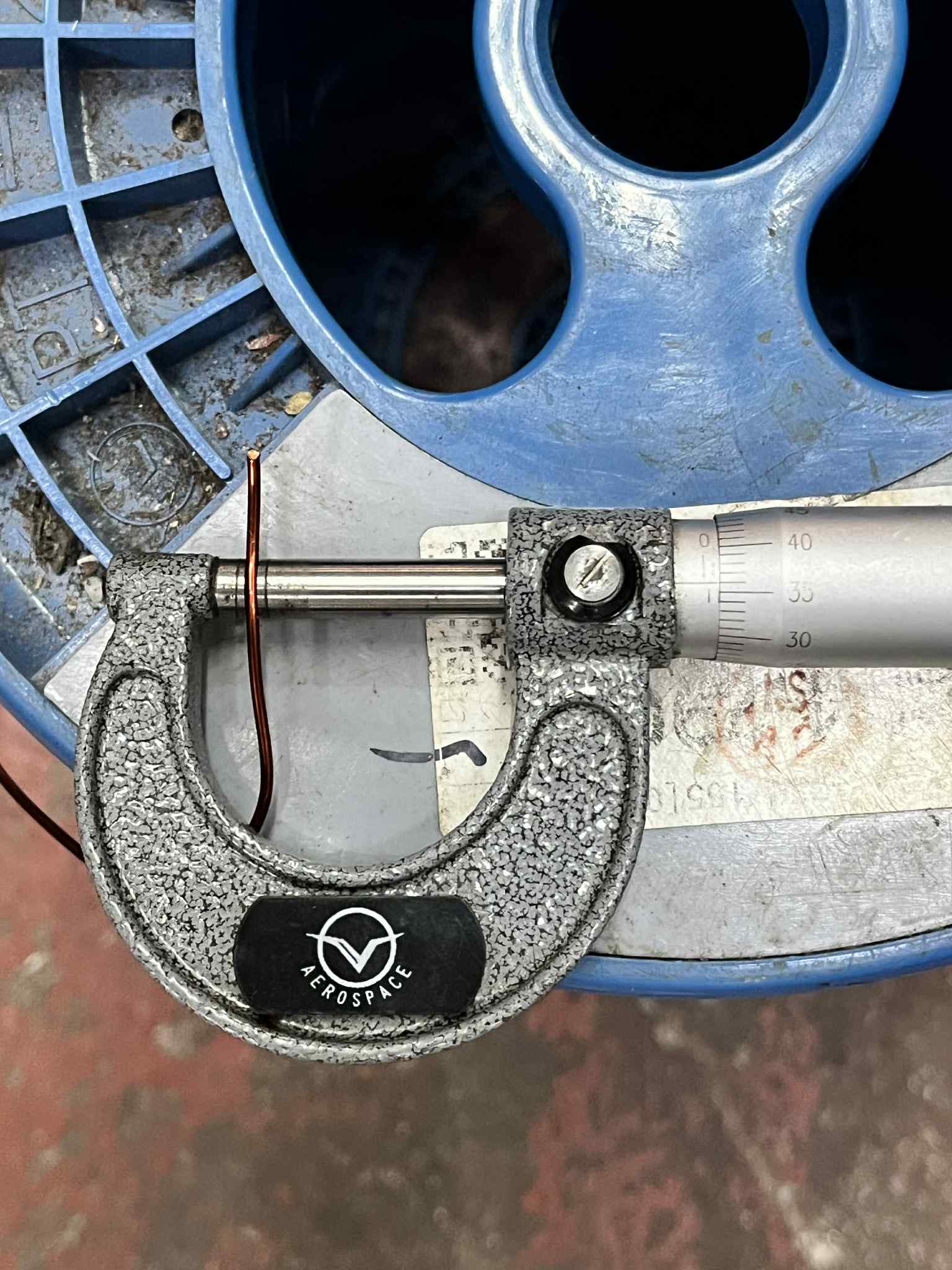 Measuring AWG 16 magnet wire Heavy Formix 800G with a micrometer on a blue spool