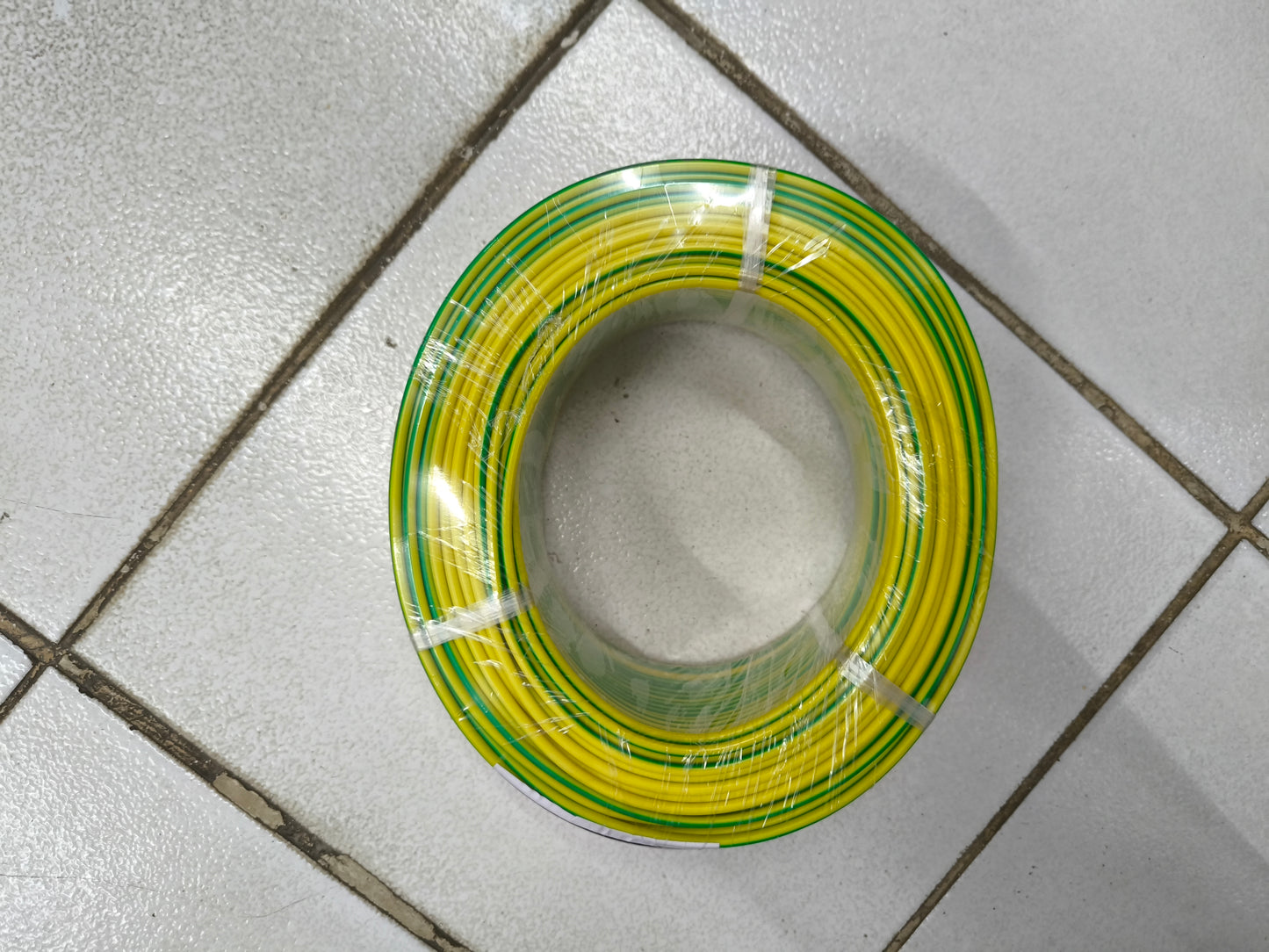 Coiled yellow and green Grounding Cable 2.0mm AWG14 wire from China on tiled floor