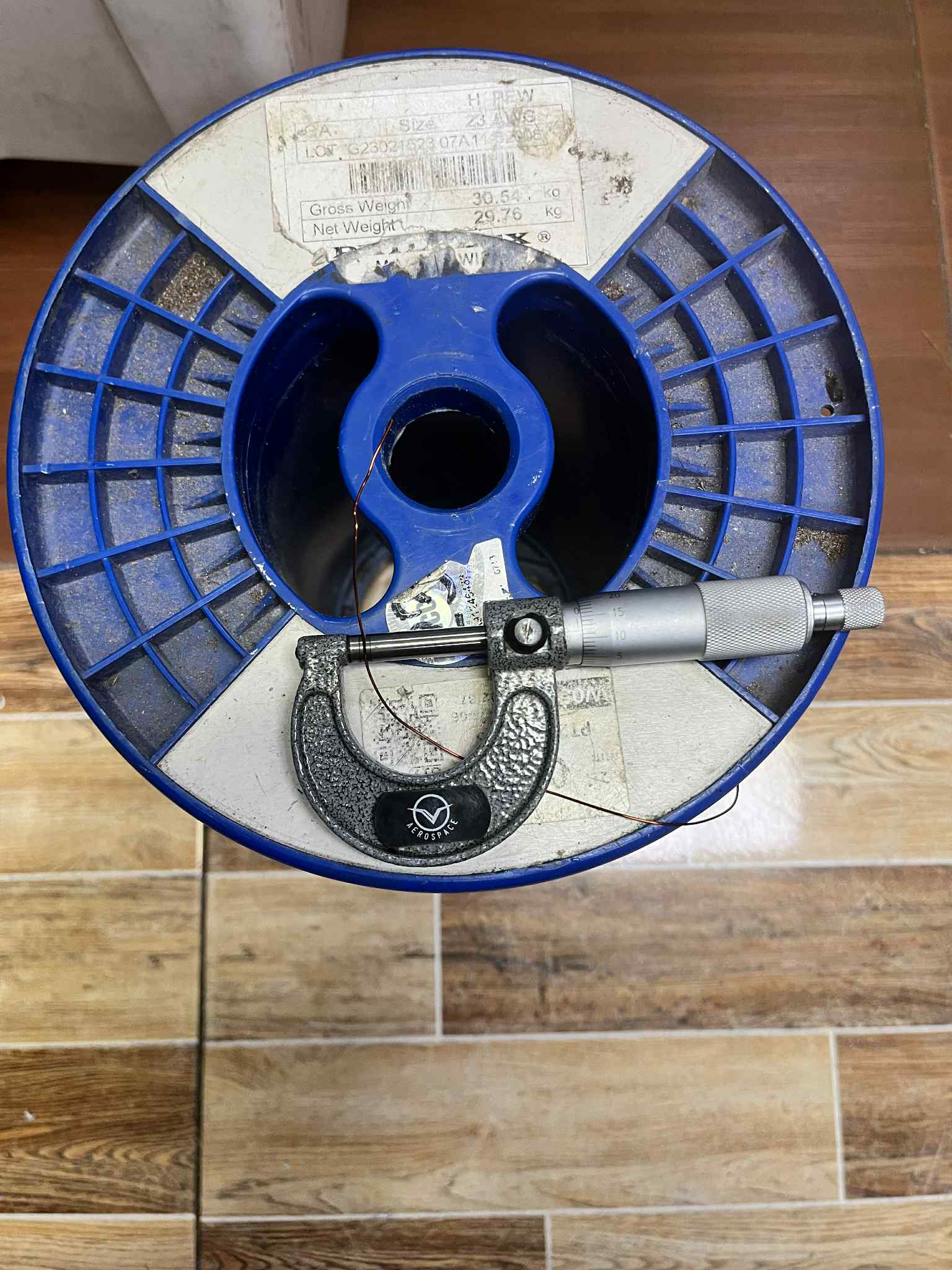 Philflex Heavy Formix magnet wire AWG 23 900G on a spool with a micrometer for measurement