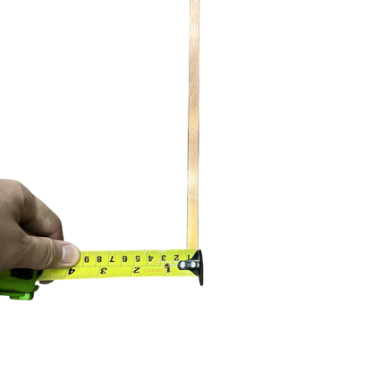 High current copper bus bar being measured with a tape measure for electrical applications