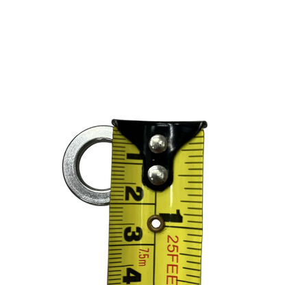 Close-up of an industrial electrical stainless washer on a measuring tape for precise measurements