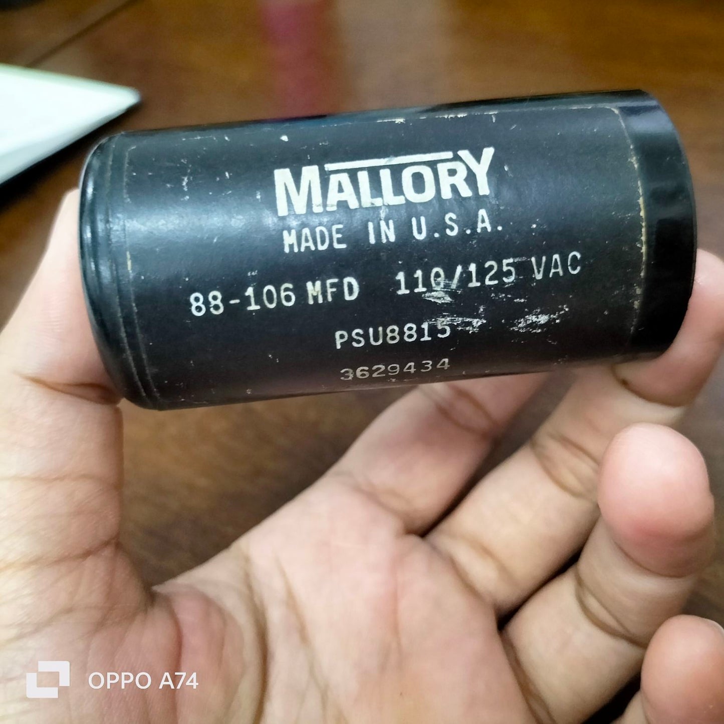 Mallory black electrical starting capacitor 88-106 MFD held in hand for circuitry use
