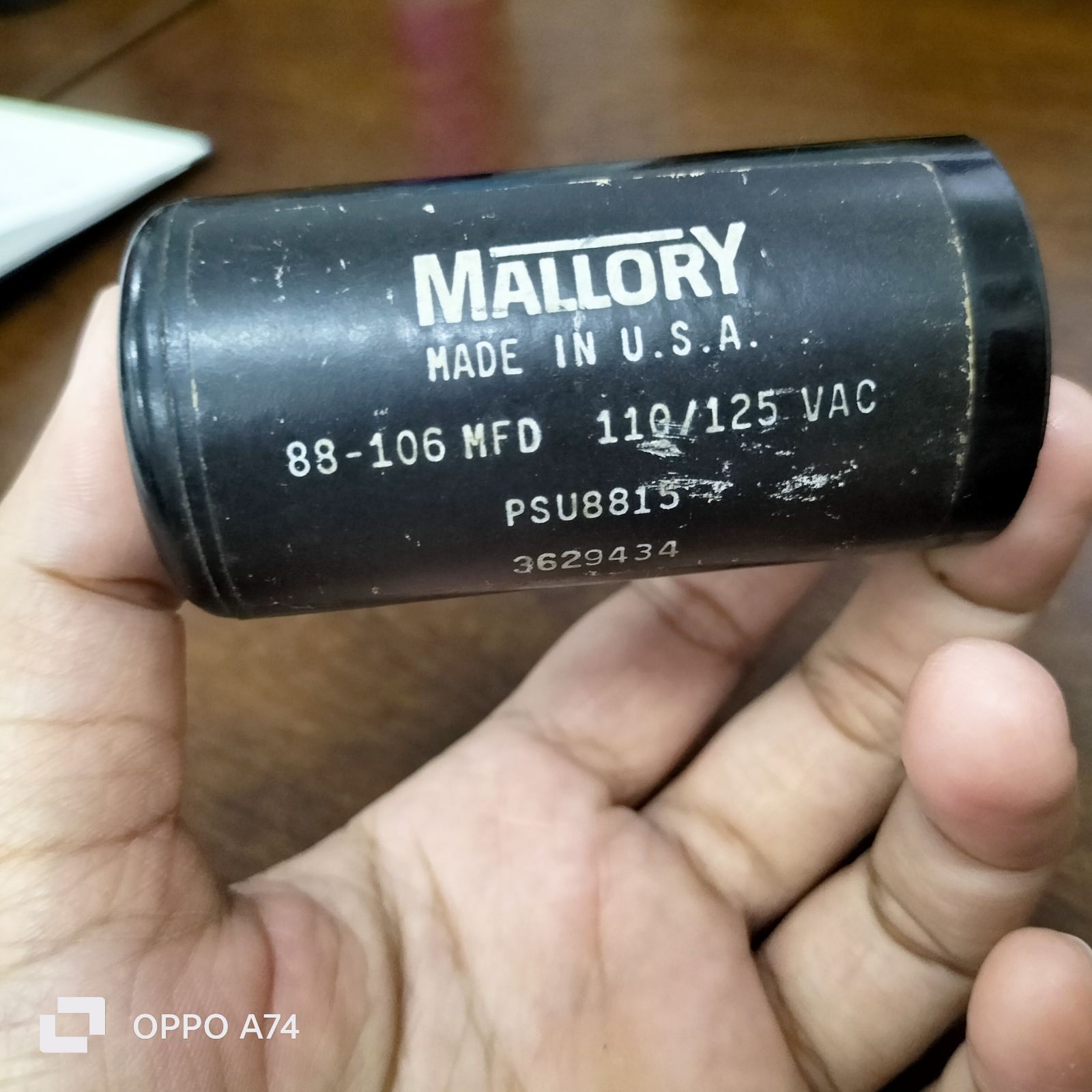 Mallory black electrical starting capacitor 88-106 MFD held in hand for circuitry use