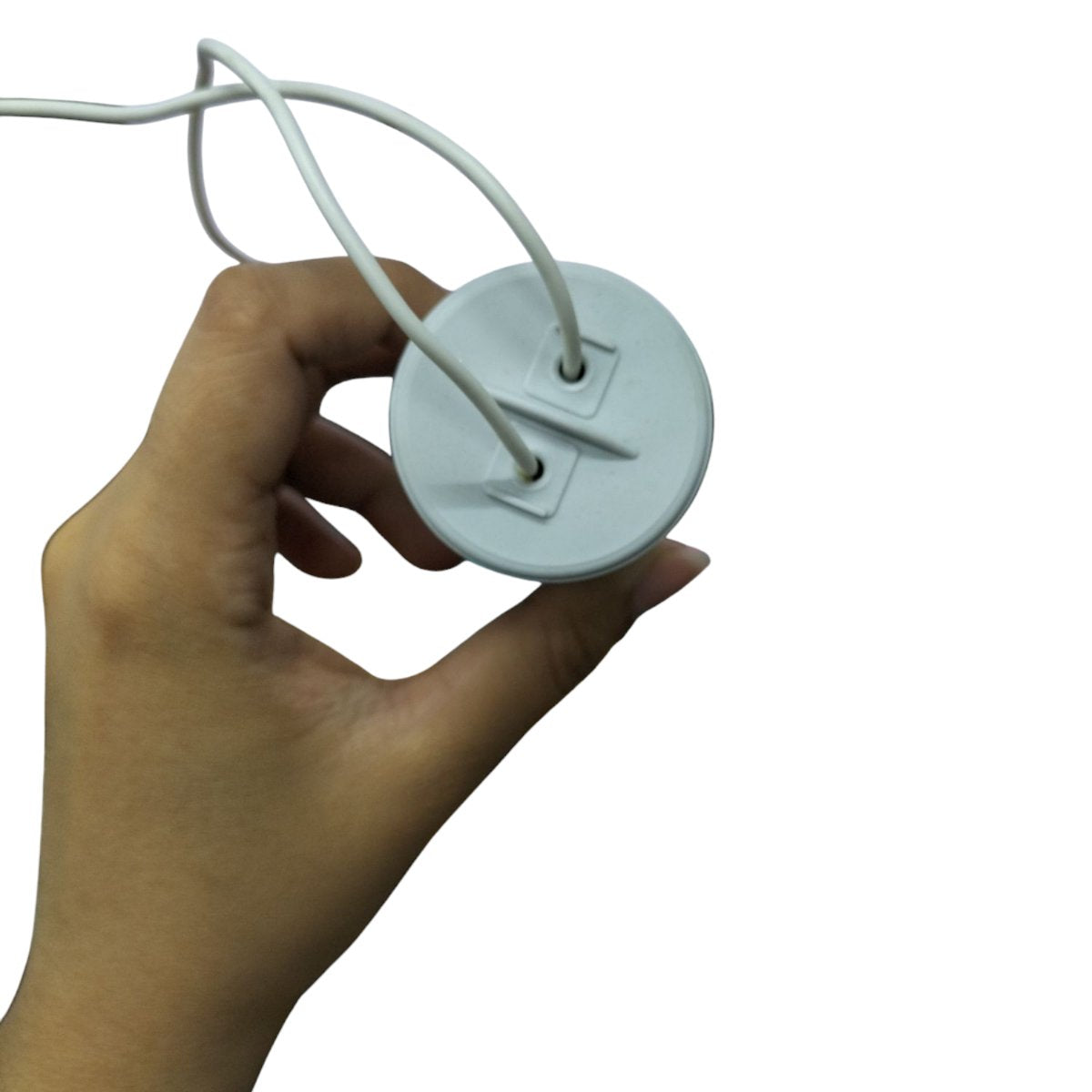 Hand holding a Syscap 70MFD 250V motor capacitor with two wires for electrical circuits
