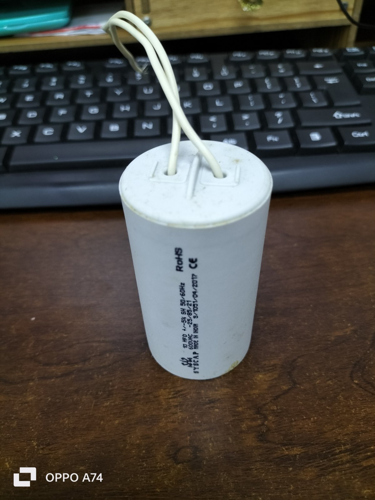 White motor capacitor with wires from Syscap used for electrical circuitry and parts