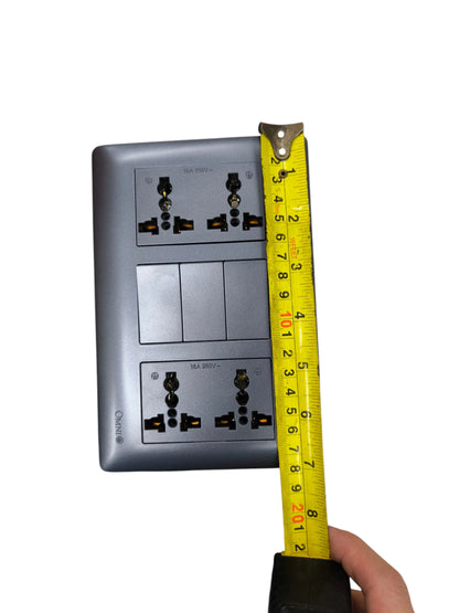 Omni 3 gang switch with 4 gang universal outlet shown with measuring tape for size reference