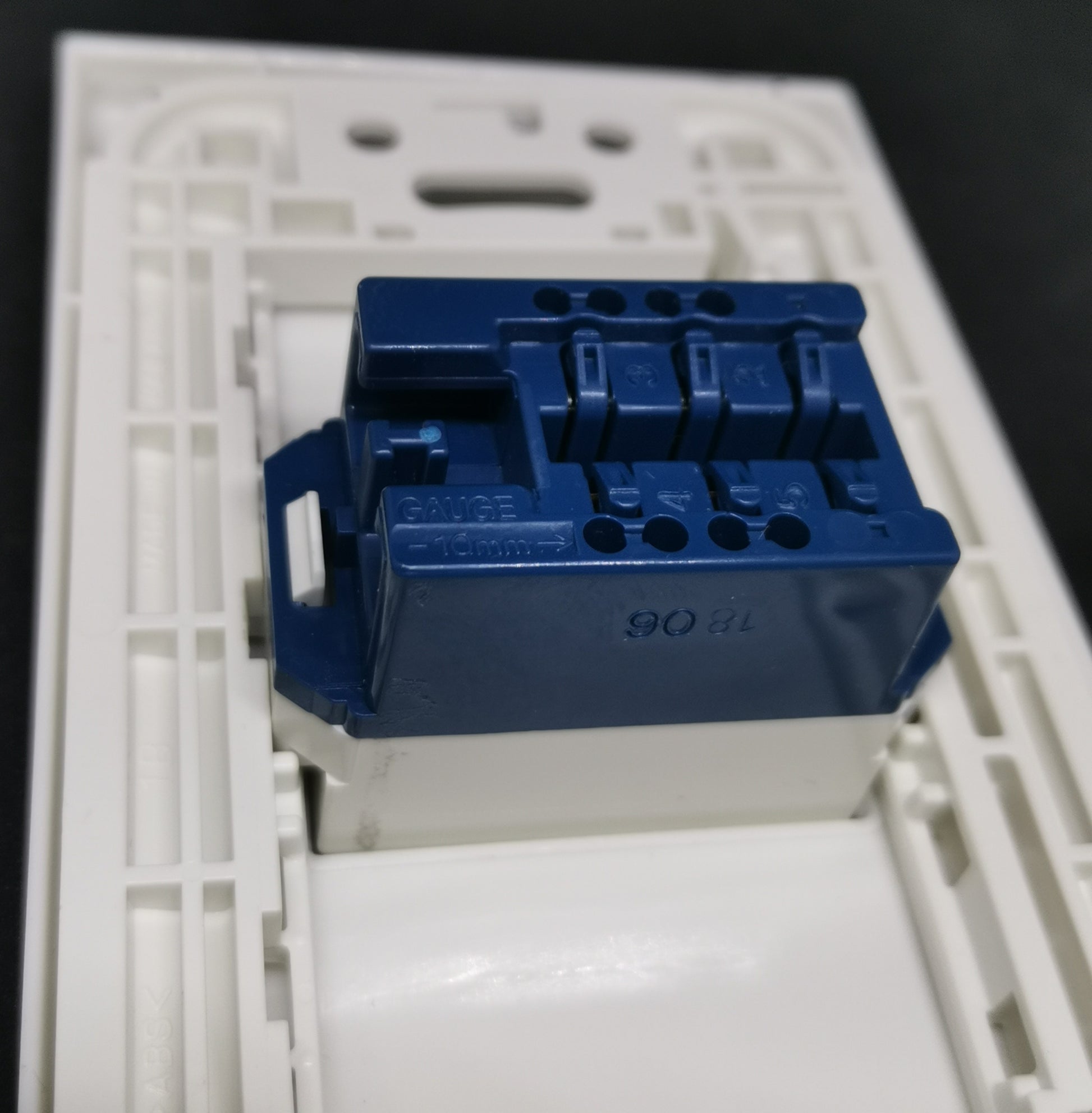 Panasonic Telephone Outlet Wide Series 1 Gang blue modular insert on white wall plate closeup