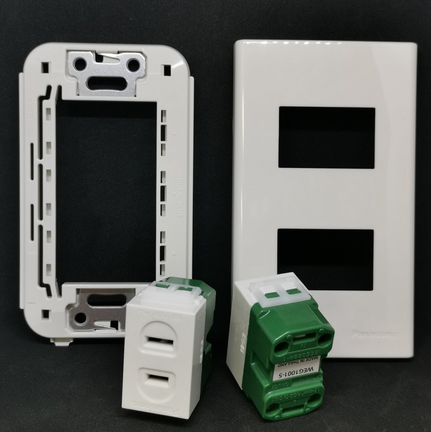 Panasonic WEG1001-5 WEG6802 outlet with a white switch plate and green power modules for electrical installations