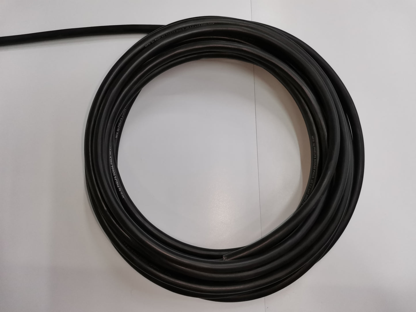 Coiled black Phelps Dodge perma cord wire for electrical and industrial applications