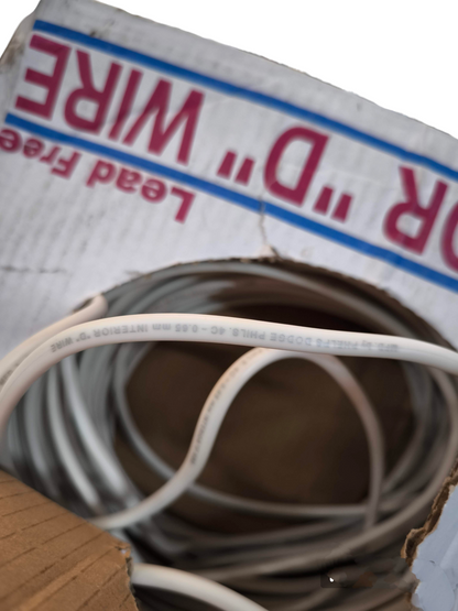 Phelps Dodge Telephone Jacketed Wire 22 coiled inside a cardboard box for electrical use