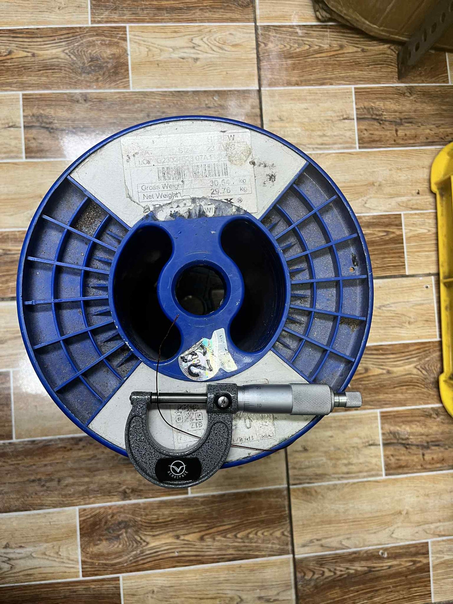 Philflex magnet wire AWG 23 1 KG on a spool with a micrometer measuring tool for precision