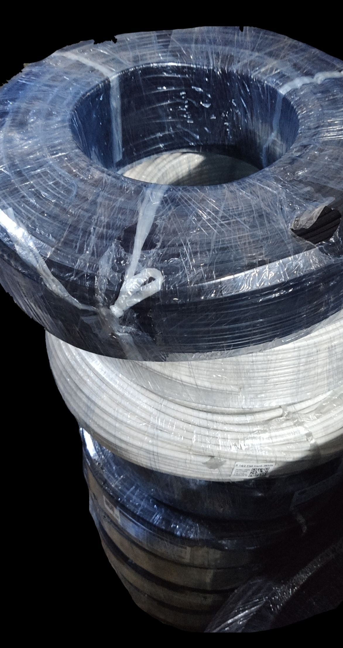 Coiled rolls of black and white Philflex flat cord wire AWG 12 - 2C wrapped in plastic for electrical wiring