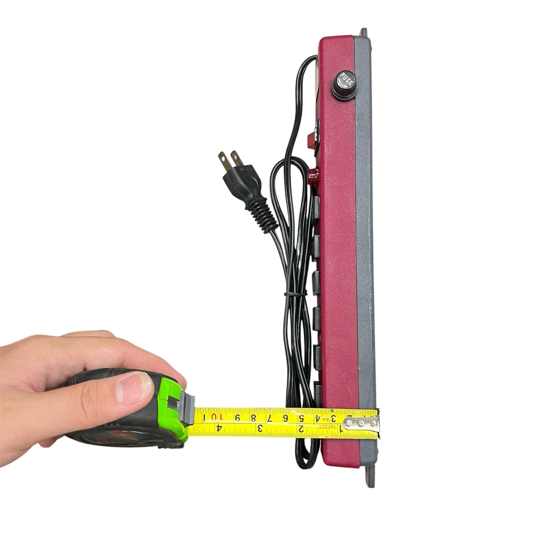 Red 6 gang extension outlet power strip being measured with a tape measure showing its length