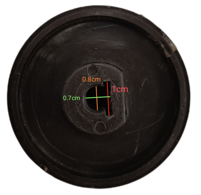 Black stove knob for electric stove with measurements on a dark background