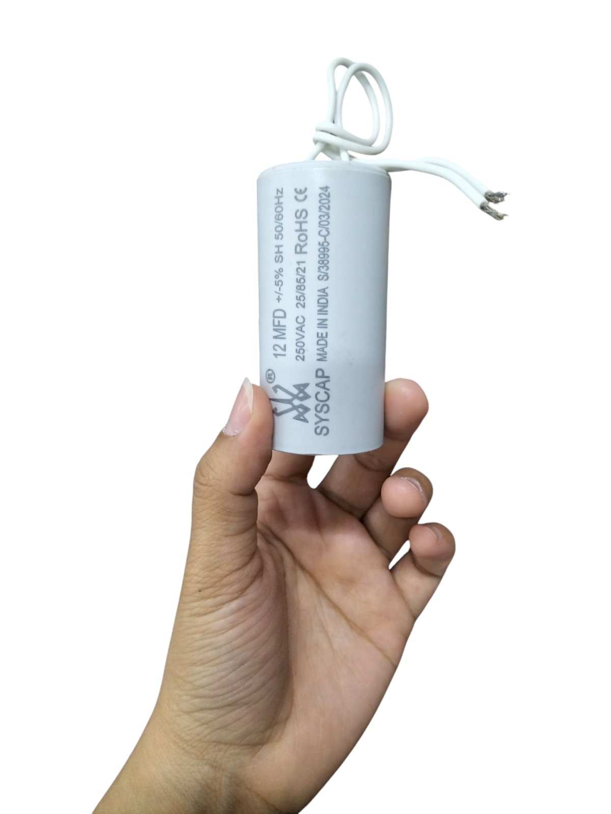 Hand holding Syscap 12MFD 250 VAC Running Capacitor electrical component with wires attached