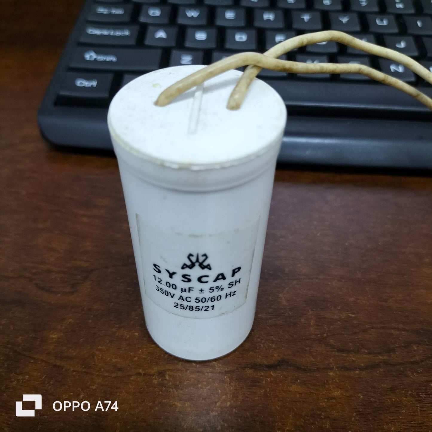 Syscap 12UF Motor Running Capacitor white cylindrical electrical part with wires on wooden surface