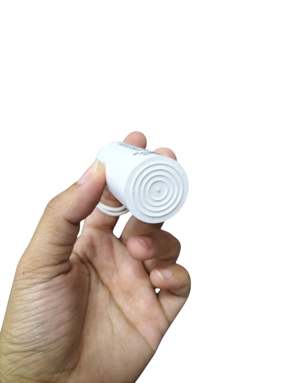 Syscap 250V AC motor running capacitor held in hand with a compact design for electrical applications