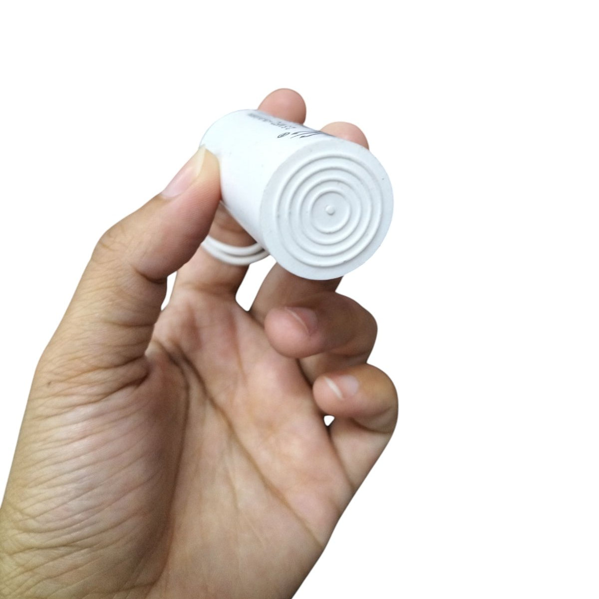 Syscap 250V AC motor start capacitor held in hand, designed for efficient motor performance
