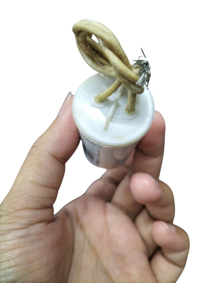 Hand holding a SYSCAP 350VAC running capacitor with two wires for electrical circuits