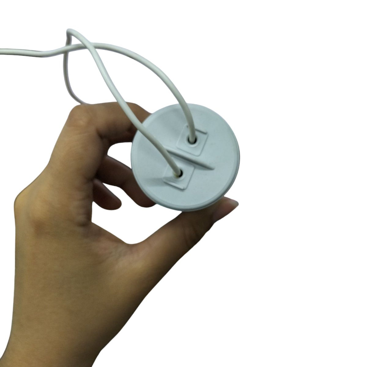 Hand holding a Syscap 55uF motor run capacitor 450V with attached wires for electrical applications
