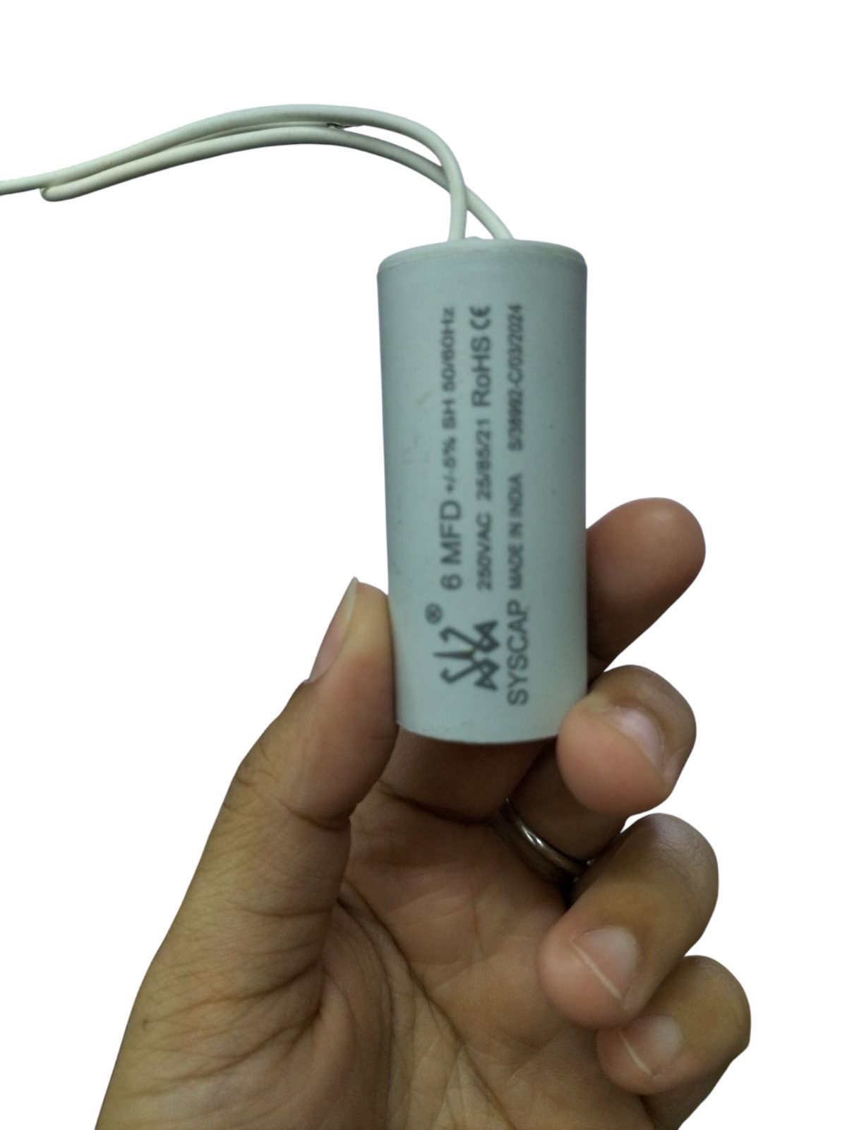 SYSCAP 6mfd 250V running capacitor for motors held in hand with white wires attached