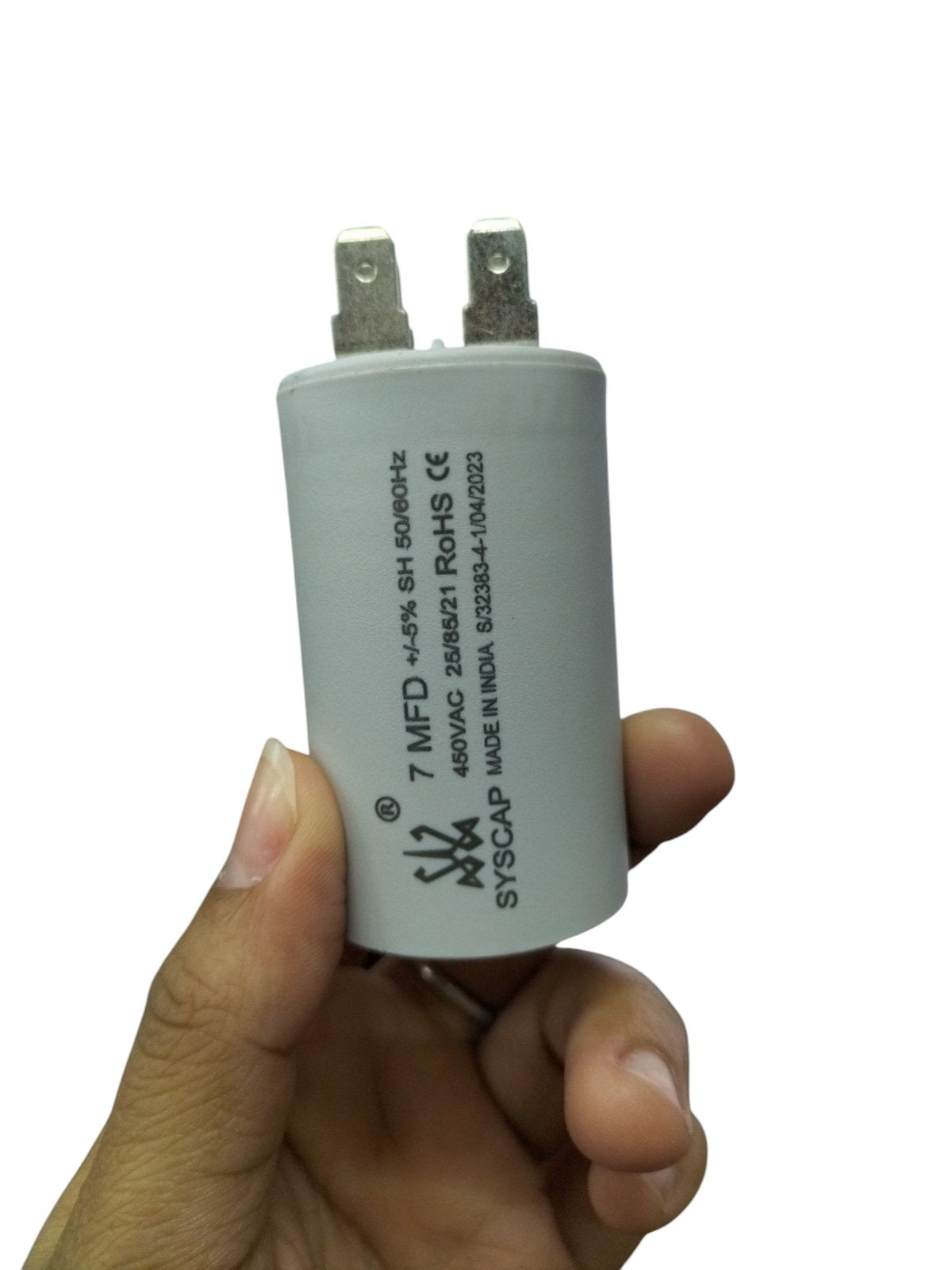 Syscap 7MFD 450Vac Run Capacitor electrical part held between thumb and fingers