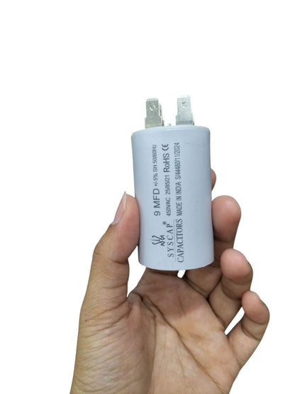 Hand holding a Syscap 9MFD 450 VAC Running Capacitor for electrical circuitry and parts