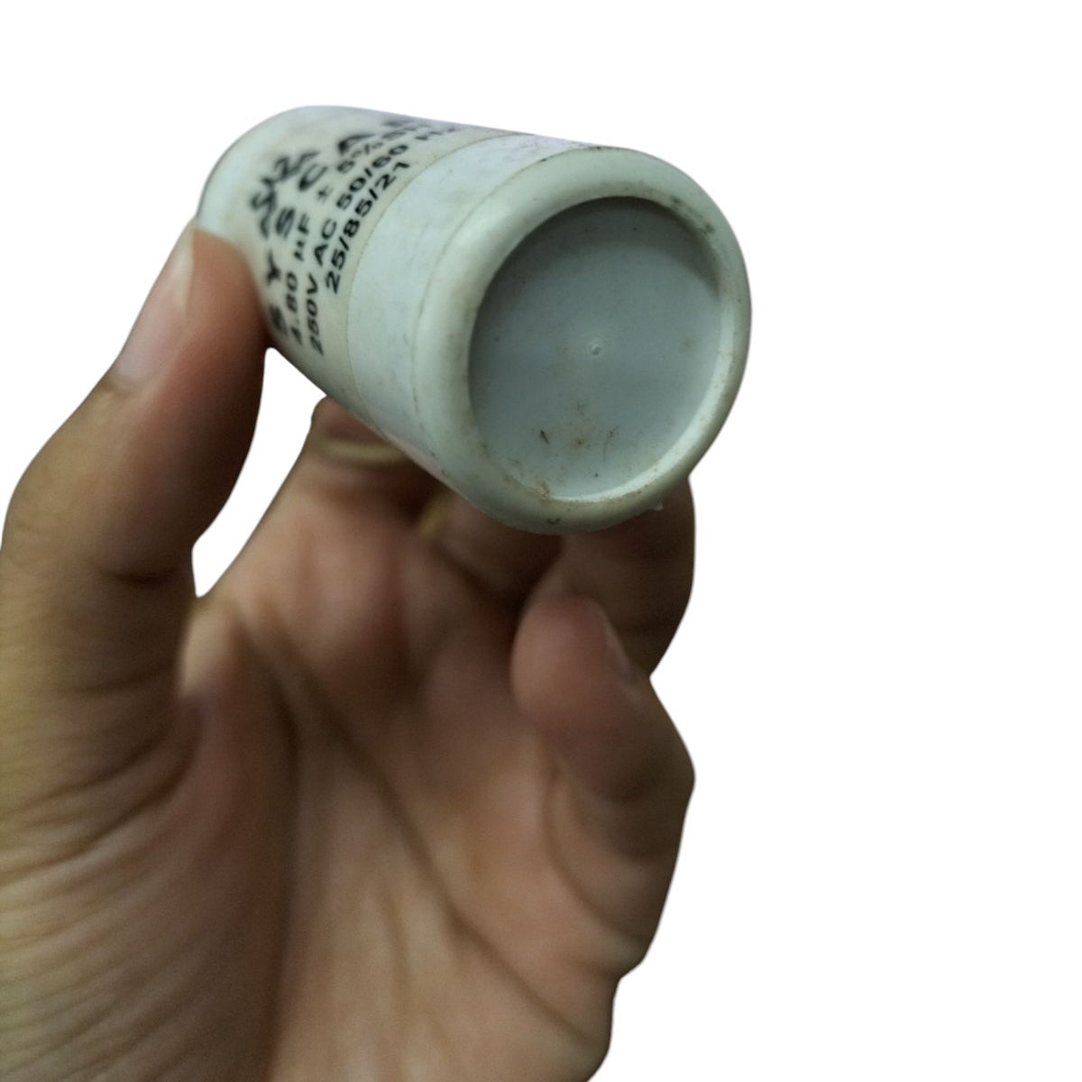 Hand holding a SYSCAP motor capacitor 250V AC showcasing its cylindrical design and printed specifications