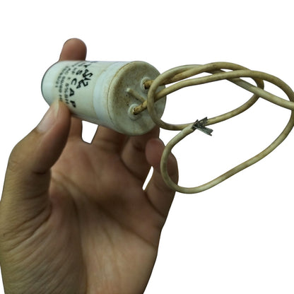 SYSCAP motor capacitor 250V AC held in hand with visible electrical connections and labeling