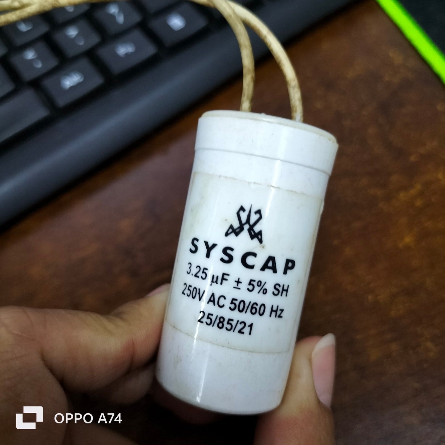 Syscap white motor capacitor 3.25 microfarad 250V AC electrical circuitry part held in hand