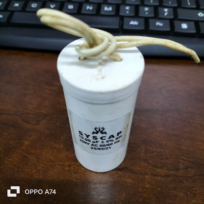 Syscap motor running capacitor 15mfd white cylindrical electrical component with wires on keyboard background